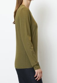 Olivgrön långärmad topp i mjukt, lättviktigt tyg. Sitter tätt med rund halsringning och sömlösa muddar.