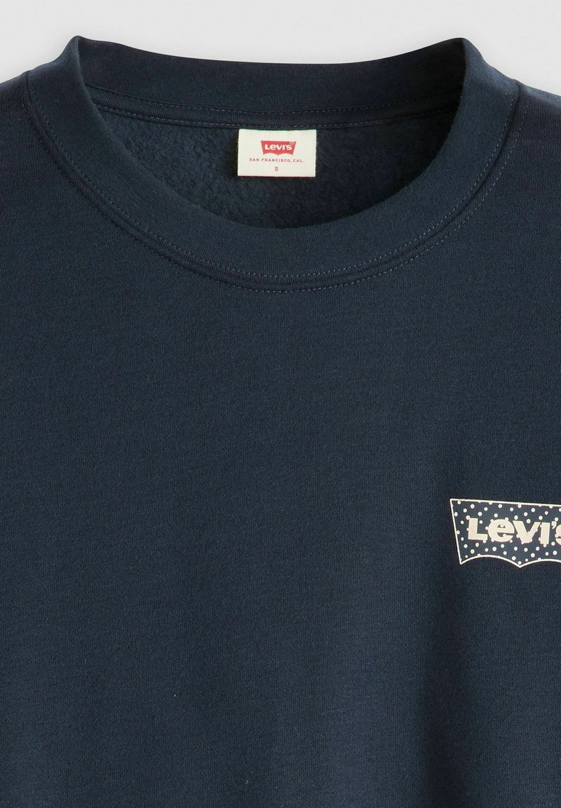 Granatowa bawełniana koszulka z okrągłym dekoltem, z małą białą naszywką z logo Levi's na lewej piersi oraz gładką, równą teksturą.
