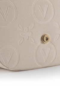 Borsa in pelle beige con texture, caratterizzata da loghi a "V" in rilievo, dettagli floreali e chiusura con bottone a pressione in tonalità oro.