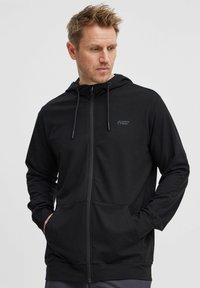 Svart zip-up hettegenser laget av glatt stoff. Har en frontlomme, sn�øring i hetta og lite logo på venstre bryst.
