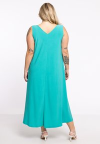 Türkis, ärmelloses Maxikleid mit V-Ausschnitt und lockerer Passform. Mit glatter Textur, fließender Form und geschichtetem Saum.