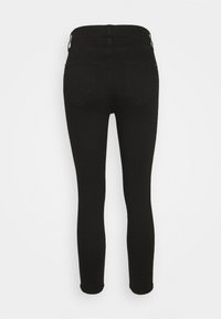 Jeans skinny negros con una textura suave. Cuentan con una cinturilla estándar, dos bolsillos traseros y un diseño elegante y ceñido.