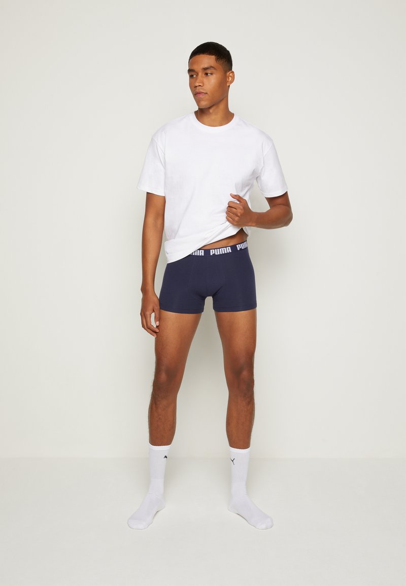 Navy boxer briefs with a white Puma logo waistband, paired with a plain white short-sleeve t-shirt and white Puma socks.