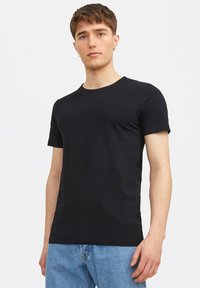 Schwarzes T-Shirt mit kurzen Ärmeln aus weichem Baumwollstoff, mit Rundhalsausschnitt und tailliertem Design. Einfach ohne Muster oder Akzente.