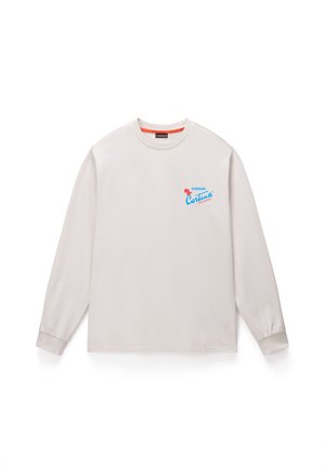 Lyse beige langærmet T-shirt lavet af bomuld, med et blåt og rødt grafik med "Cortina Dolomiti" på venstre bryst.