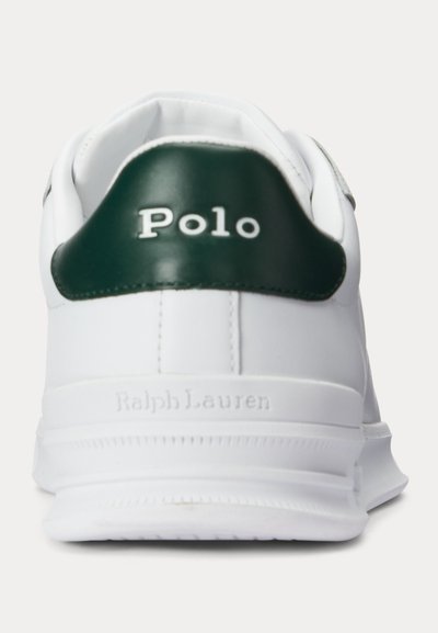 Biely pätka tenisky s tmavozelenou koženou záplatou označenou Polo a vystúpeným nápisom Ralph Lauren na bielej podrážke.