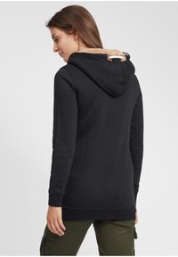 Felpa nera con cappuccio e fodera in pile beige al collo. Presenta un accento in pelle marrone e maniche lunghe. Tessuto di cotone morbido.