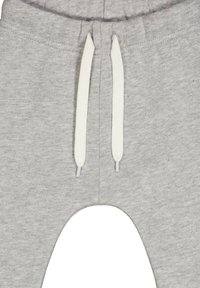 Grijze sweatpants met een zachte textuur, elastische tailleband en witte trekkoorden. Opvallend uitsnijdontwerp bij de knieën.