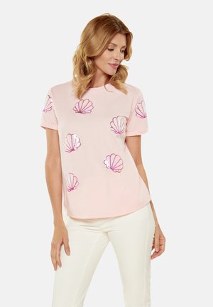 Tricou roz deschis cu mânecă scurtă, având motive cu scoici roz strălucitoare. Material moale, cu o croială lejeră și decolteu rotund.