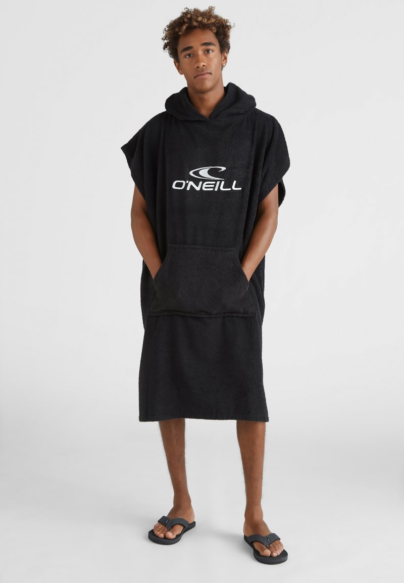 Poncho asciugamano nero con cappuccio, realizzato in morbido tessuto di spugna, con tasca frontale e logo "O'Neill" in bianco. Indossato con ciabatte.