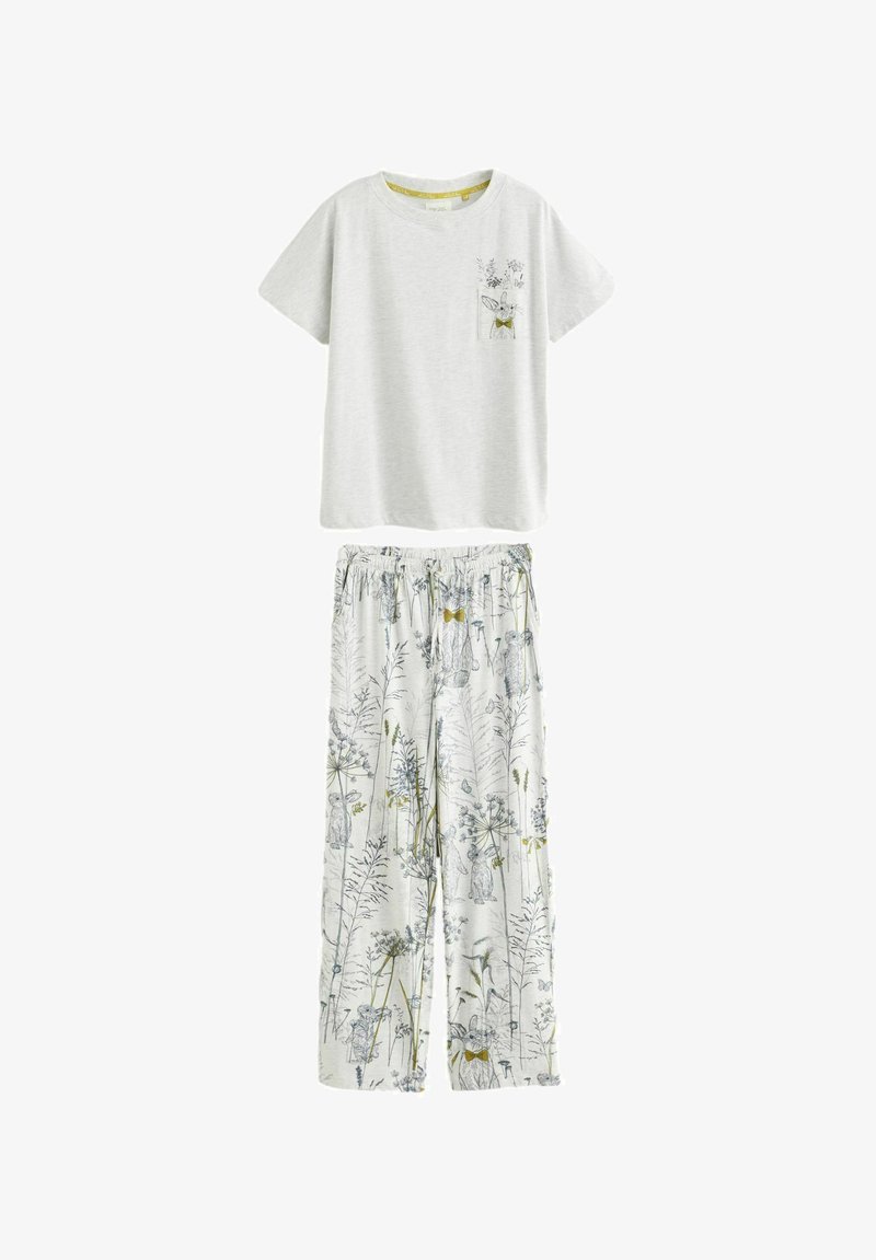 Camiseta gris de manga corta con un bolsillo y un diseño de conejo floral, combinada con pantalones blancos de corte holgado con estampados botánicos.