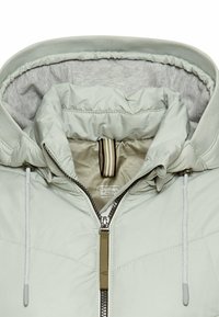 Light green puffer jacket with a grey fleece lining, featuring a high collar, front zipper, and drawstrings at the hood.