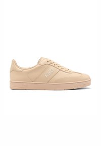 Beež nahast pe sneakers, millel on tekstureeritud pind, ümar varvas, lame paelad ja "RKO" reljeefne kiri külje ja kand ära. Kummist tallad vastupidavuse tagamiseks.