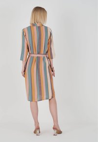 Gestreiftes Hemdkleid in mehreren Farben mit dreiviertel Ärmeln, einer Taillenschnürung und knielanger Länge. Weicher Stoff mit glatter Textur.