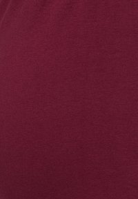 Texture de tissu bordeaux uni avec un motif de maille fine et un léger effet chiné.
