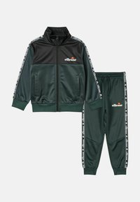 Ensemble de survêtement ellesse vert et noir comprenant une veste zippée et un pantalon à poignets élastiques avec bande à logo sur les manches et les côtés du pantalon.