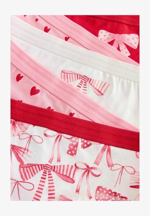 Suurendatud vaade voltitud roosa ja punase alusharja peale, millel on südame ja paelamuster pehmest kangast.