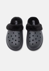 Saboti negri cu căptușeală moale din blană neagră, având orele de ventilare mari, confecționați dintr-un material rezistent, cu vârf rotunjit și talpă texturată.