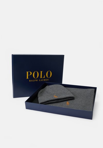 Sivi pleteni zimski šešir i šal, upakirani u mornarsku plavu kutiju s zlatnim logom "POLO RALPH LAUREN". Mekana tekstura, minimalistički dizajn i izvezena detaljna obrada.