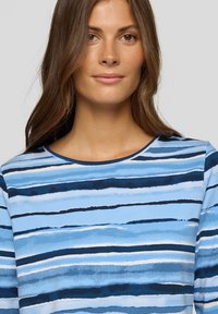 Blau gestreiftes Hemd mit verschiedenen Schattierungen von Hellblau bis Dunkelblau sowie weißen und marineblauen Linien. Abgerundeter Ausschnitt, weicher Stoff und lässiger Schnitt.