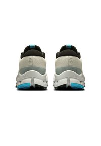 Sportliche Schuhe mit grauem Obermaterial und schwarzen Akzenten, gepolstertem Absatz und türkisfarbenen Details; strukturierte Oberfläche, runde Form und Gummisohle.
