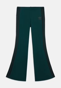 Tyrkis utsvängda byxor i stretchigt material, med svarta sidostrikar och en adidas-logotyp framtill. Slät textur och figursydd midja.