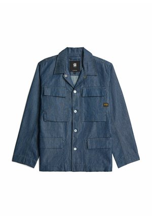 Denim jacket in dark blue with a button-up front, pointed collar, and multiple front pockets. Features contrasting stitching and hardware accents.