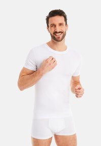 White cotton t-shirt with short sleeves, round neck. Paired with white boxer briefs, smooth texture and fitted design.