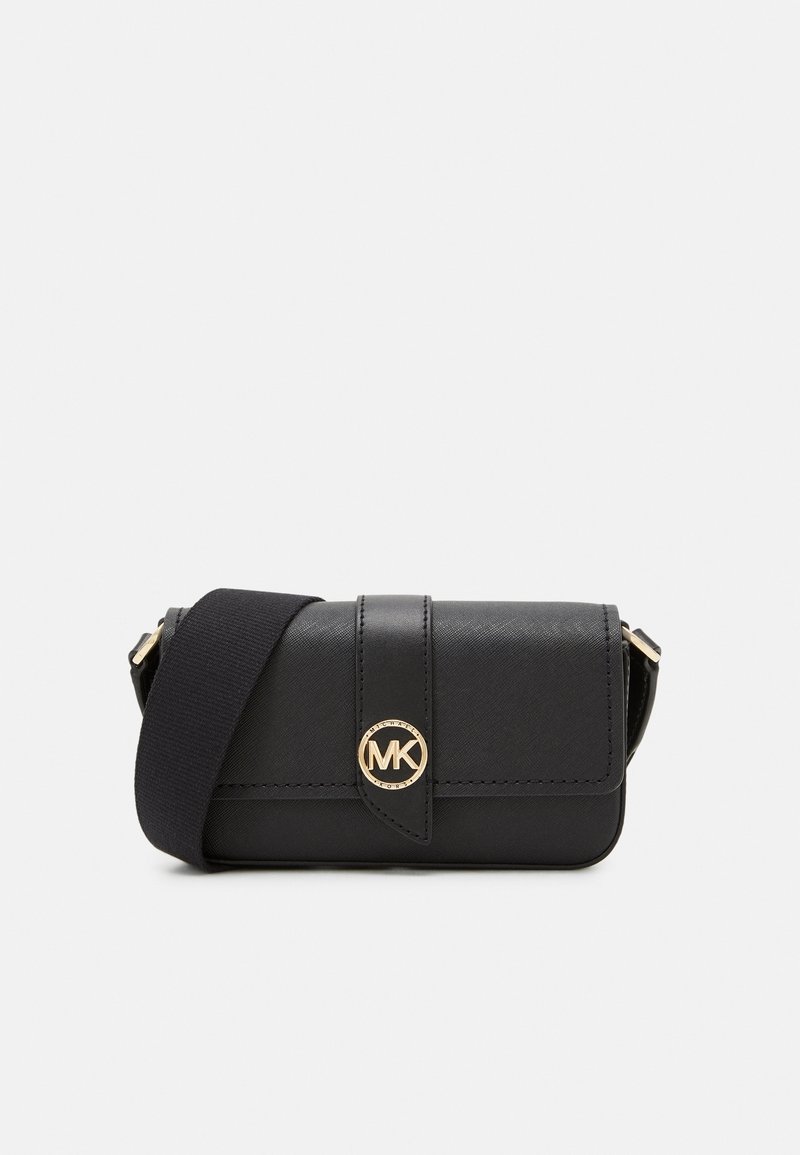 Bolso bandolera de piel negra con un logo dorado de MK, que cuenta con un cierre tipo solapa, superficie texturizada y una correa de tela. Diseño compacto y rectangular.