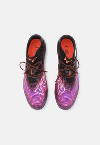 Black and purple athletic shoes with a textured design, featuring orange accents, patterned upper, and round laces.