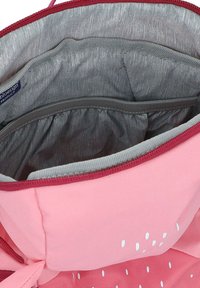 Das Innere der rosa Stofftasche verfügt über eine graue Innenfütterung, mehrere Taschen und elastische Netzfächer. Das Außenmaterial ist mit einem Muster aus weißen Punkten versehen.