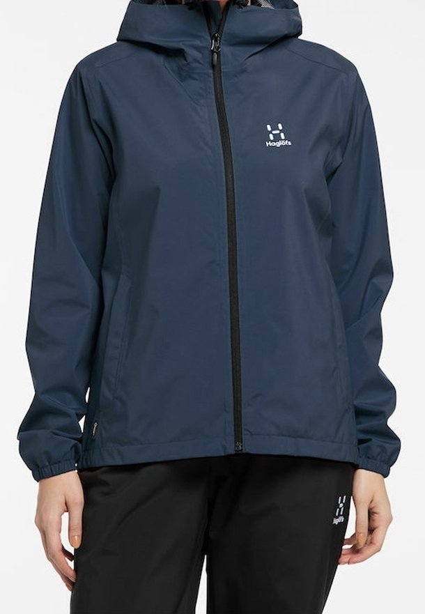 Veste imperméable bleu marine avec fermeture éclair à l'avant, capuche ajustable et poignets élastiques. Dispose d'un logo sur la poitrine et de deux poches latérales.