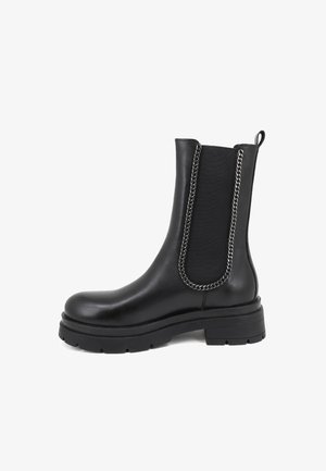 Stivaletto in pelle nera con pannelli elastici laterali, dettaglio in catena, punta rotonda e suola in gomma spessa per una migliore aderenza.