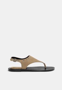 Brązowe zamszowe sandały z odkrytą palcą, pasek na kostkę z metalowym zapięciem oraz dekoracyjnymi oczkami. Czarna podeszwa z przeszytymi brzegami.