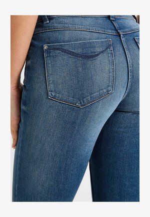 Vaqueros de mezclilla azul oscuro con un diseño clásico de bolsillo y costuras detalladas. La tela tiene una textura suave con un desgaste sutil.