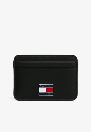 Portatarjetas de imitación de cuero negro con múltiples ranuras para tarjetas, que presenta una placa de metal rectangular con un logotipo en azul, rojo y blanco en el frente.