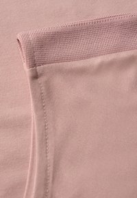 Tessuto rosa chiaro con una consistenza liscia e un accento leggermente rigato. Presenta cuciture pulite e un dettaglio di bordo ripiegato.