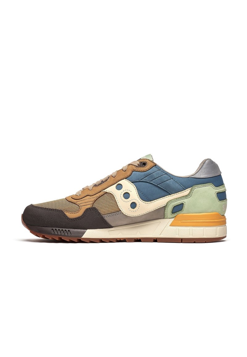 Multikleurige sneaker met bruine, groene, blauwe en crèmekleurige panelen, gemaakt van mesh en suede materialen, met een textuurovervlak en een rubberen zool.