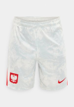 Valkoiset urheilushortsit, joissa on hienovarainen pilvikuvio, oikeassa lahkeessa punainen Nike-logo ja vasemmassa lahkeessa punavalkoinen Puolan kansallisembleemi.