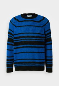 Pull rayé bleu et noir, texture tricotée, col rond, avec des rayures horizontales de largeurs variées. Poignets et ourlet côtelés.