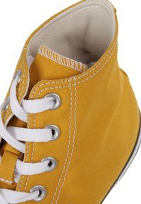 Gul canvas hög snörkänga med vita snören, förstärkta öglor och kontrasterande sömmar. Mjuk innervadding synlig vid öppningen.