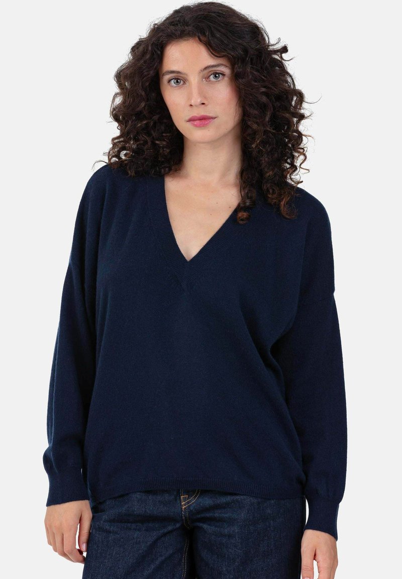 Pull en maille bleu marine avec col en V, manches longues et coupe décontractée. Fabriqué en tissu doux, avec poignets et ourlet côtelés.