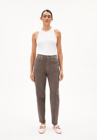 Grey corduroy pants with a slim fit, featuring a button and zip fly, five pockets, and a contrasting white tank top. Pink flat shoes included.