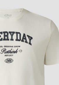T-shirt blanc avec texte noir : "EVERYDAY", "FEEL OBSERVE GROW", "Rethink", "REFLECT" et un petit graphisme de globe.