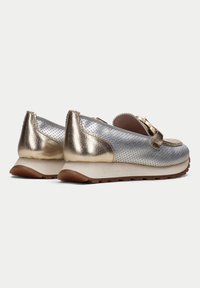 Scarpe slip-on in pelle argento e oro con texture perforata, punta rotonda e suola in gomma. Presentano un'accattivante applicazione a fiocco sul davanti.