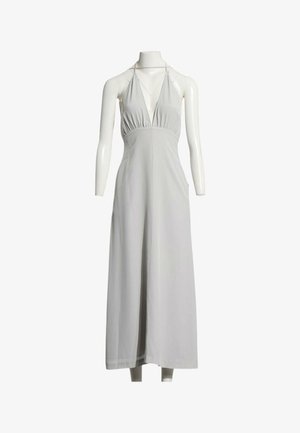 Vestido maxi blanco sin mangas con cuello halter y escote pronunciado, exhibido en un maniquí sin cabeza.