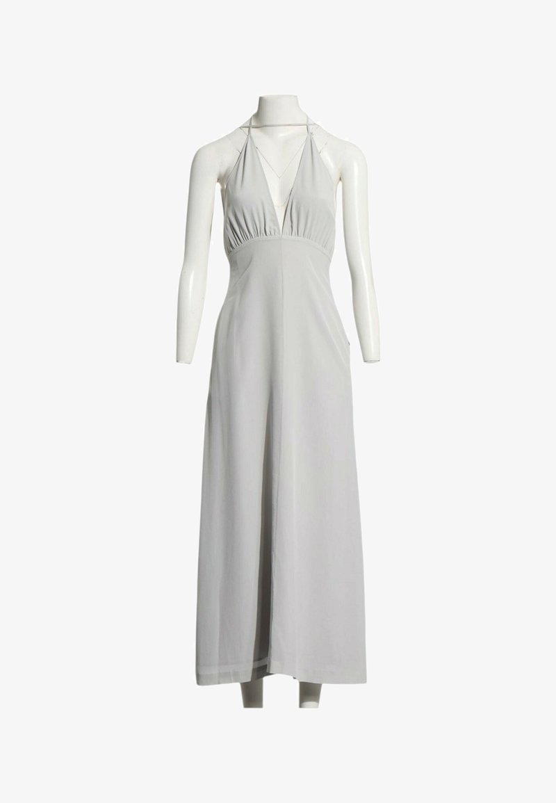 Robe maxi blanche sans manches à col licou avec un décolleté plongeant exposée sur un mannequin sans tête.