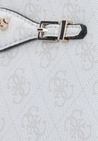 Borsa in tessuto bianco con un sottile motivo in rilievo. Il design è completato da rifiniture nere e una fibbia d'argento. Superficie testurizzata visibile.