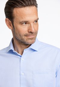 Lichtblauw button-up shirt met een gestructureerd patroon, een puntige kraag en een borstzak. Voorzien van witte knopen en een gladde stof.