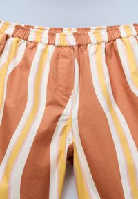 Βαμβακερά σορτς με ελαστική μέση. Διακοσμημένα με κάθετες ρίγες σε αποχρώσεις τερακότας, εκρού, κίτρινο και ροζ. Διαθέτουν πλαϊνές τσέπες.